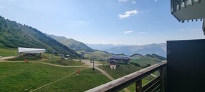 Paisagem montanhosa com um teleférico e um pequeno edifício.