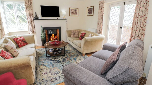 Ein Wohnzimmer mit Kamin, zwei Sofas, einem Couchtisch und einem Fernseher.