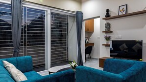 Una sala de estar con sofá, televisión y escritorio.