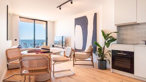 Una sala de estar moderna con un ventanal grande, un comedor y una cocina.