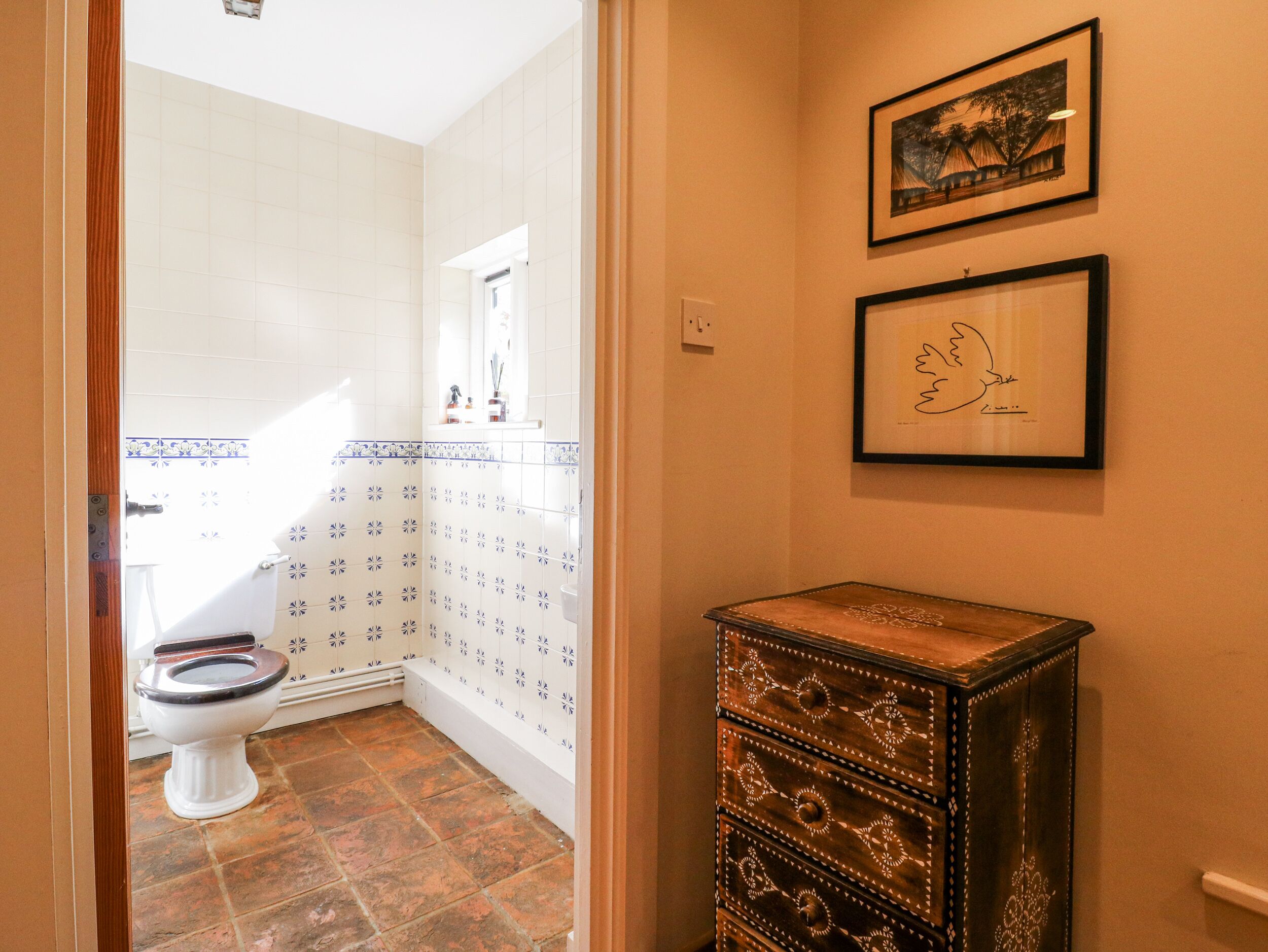 A bathroom with a toilet, a sink, and a cabinet.
