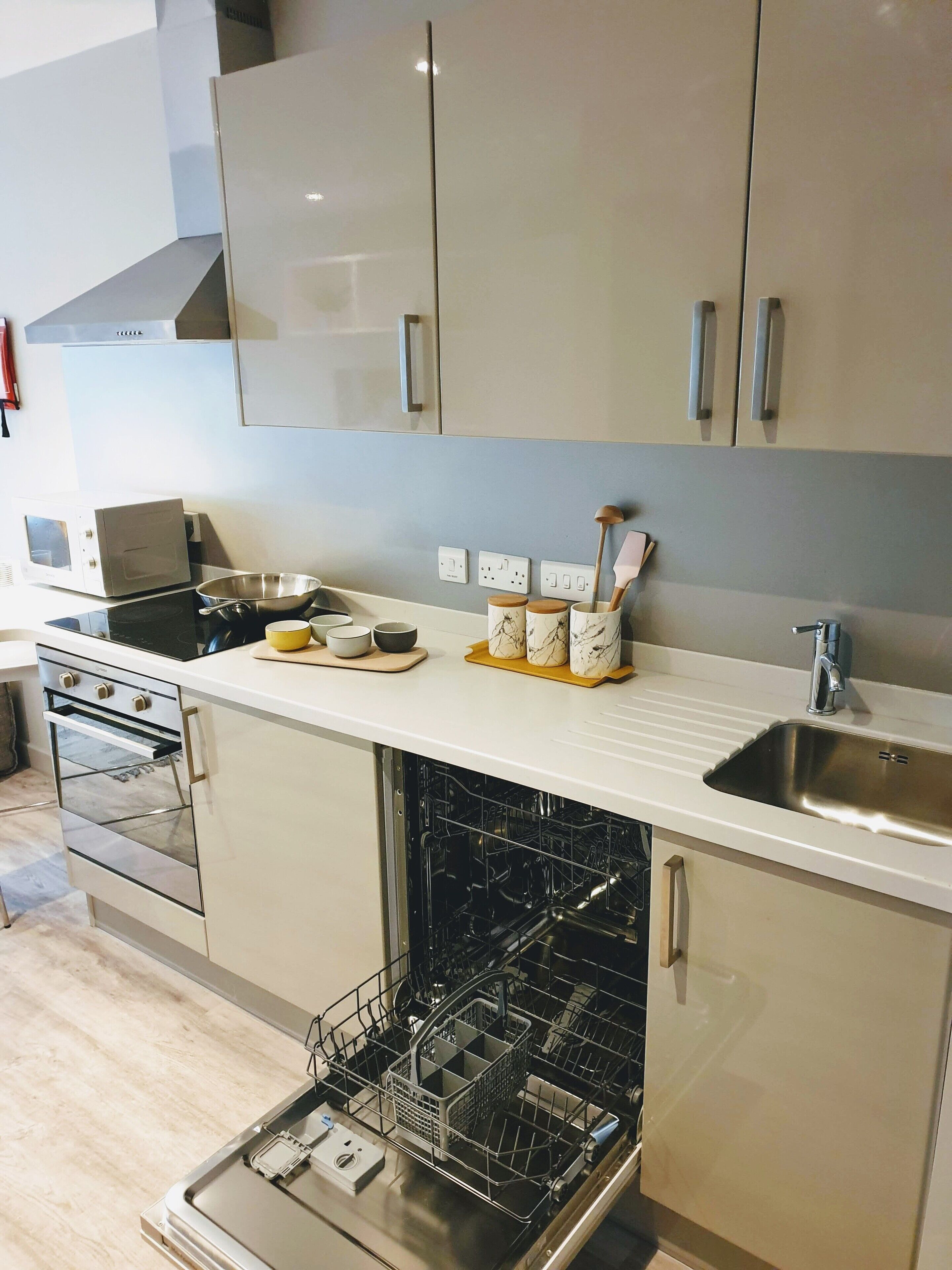 Una cocina moderna con electrodomésticos de acero inoxidable, lavavajillas y pileta.