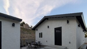 Ein modernes Haus mit einer Terrasse, komplett mit Tisch und Stühlen.