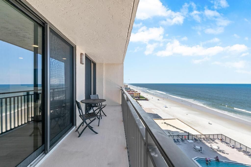 A balcony with a view of a beach and ocean.