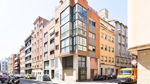 A multi-story residential building with balconies, a ground-floor entrance, and a parked yellow van. - Stay U-nique Apartments Bonsoms (Barcelona)