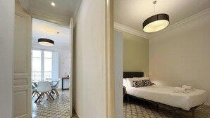 Une chambre d’hôtel avec un lit, une chaise, une table et une vue sur l’extérieur.