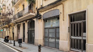 A street view of a building with barred windows, a closed shop, and a parked scooter. - Stay U-nique Apartments Passatge de Font (Barcelona)