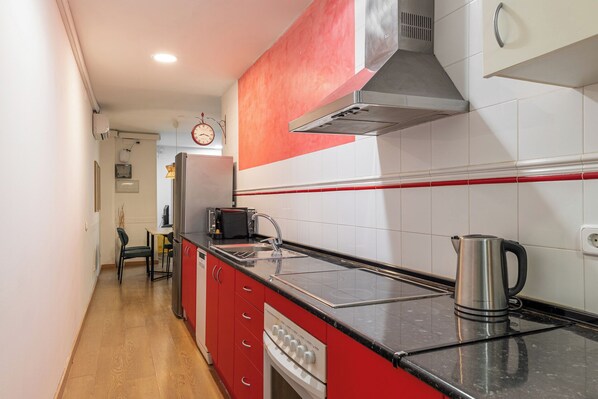A kitchen with a stove, sink, and a kettle on the counter. - Stay U-nique Apartments Passatge de Font (Barcelona)