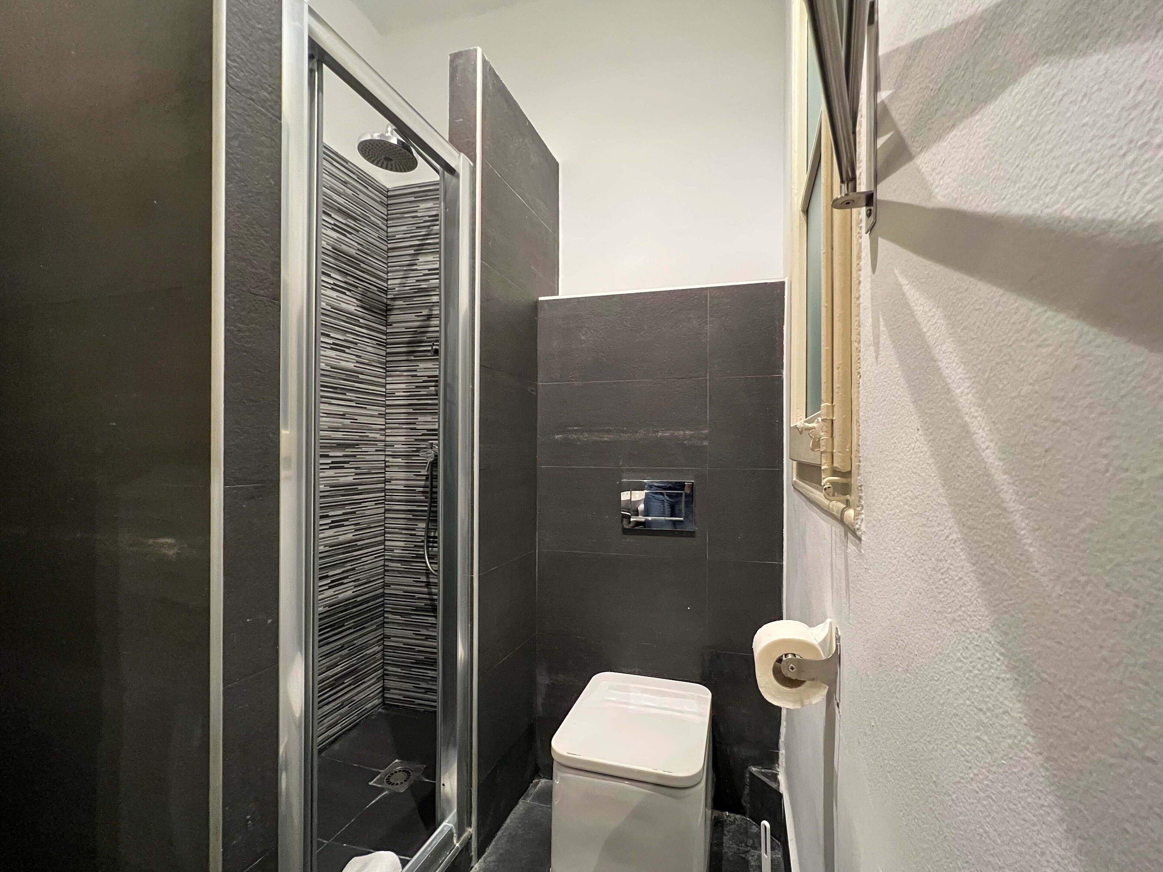 Ein kleines Badezimmer mit Dusche, Toilette und Waschbecken.