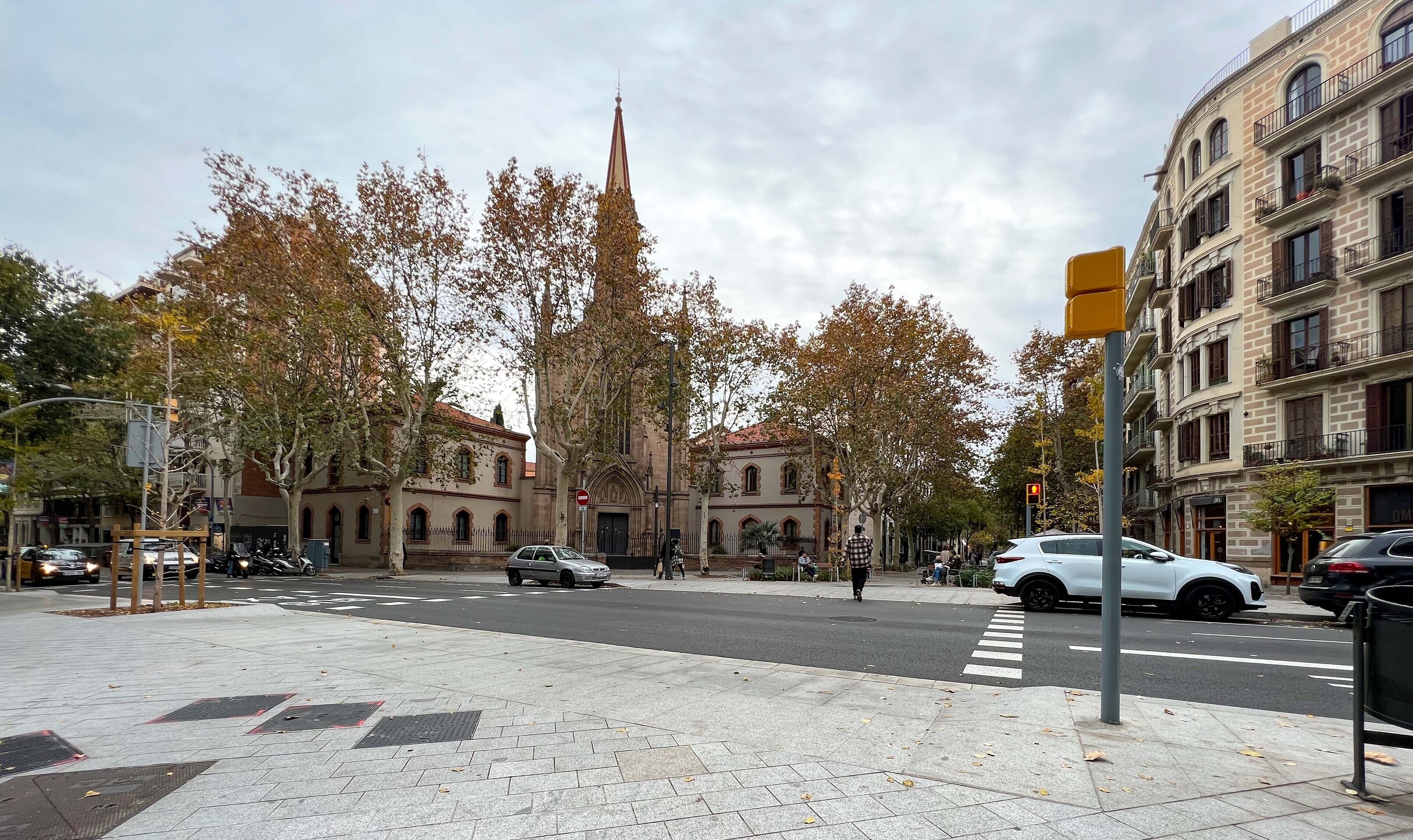 A street scene with a church, trees, and buildings.
