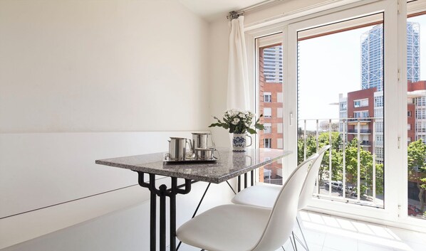 Ein Balkon mit Tisch, Stühlen und einem Blumenstrauß.