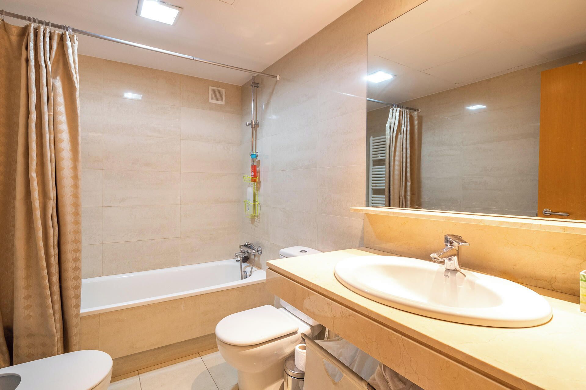 A modern bathroom with a bathtub, toilet, and sink.