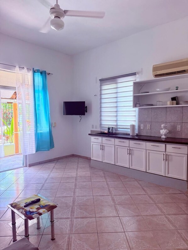 A spacious kitchen with white cabinets, a built-in stove, and a ceiling fan. - CasaLoca Cabarete (Cabarete)