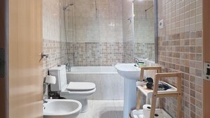 Un baño moderno con bañera, dos lavamanos, inodoro y ducha.