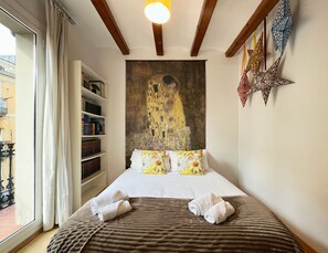 A hotel room with a large bed, a bookshelf, a painting, and a star decoration. - Stay U-nique Apartments Murillo (Barcelona)