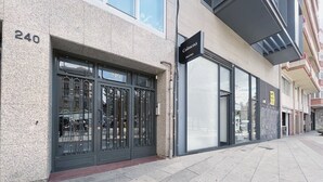Een modern gebouw met een grote glazen ingang en een bord waarop 