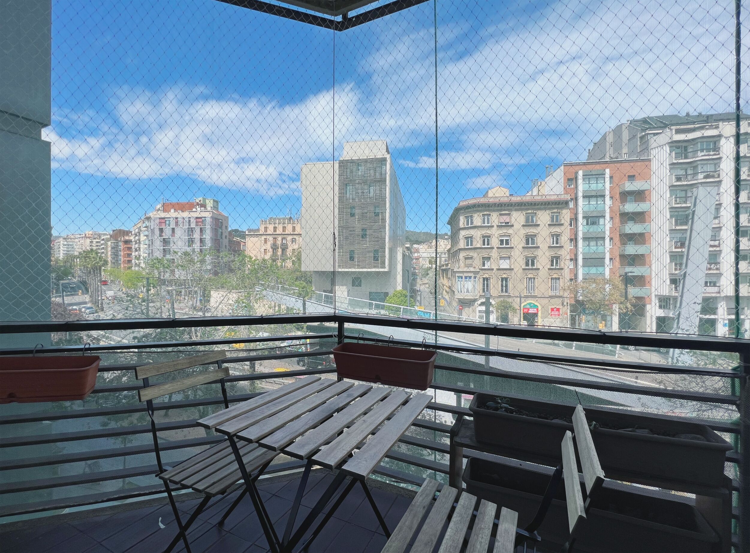 Uma varanda com vista para a paisagem urbana, incluindo vários edifícios e um céu limpo.