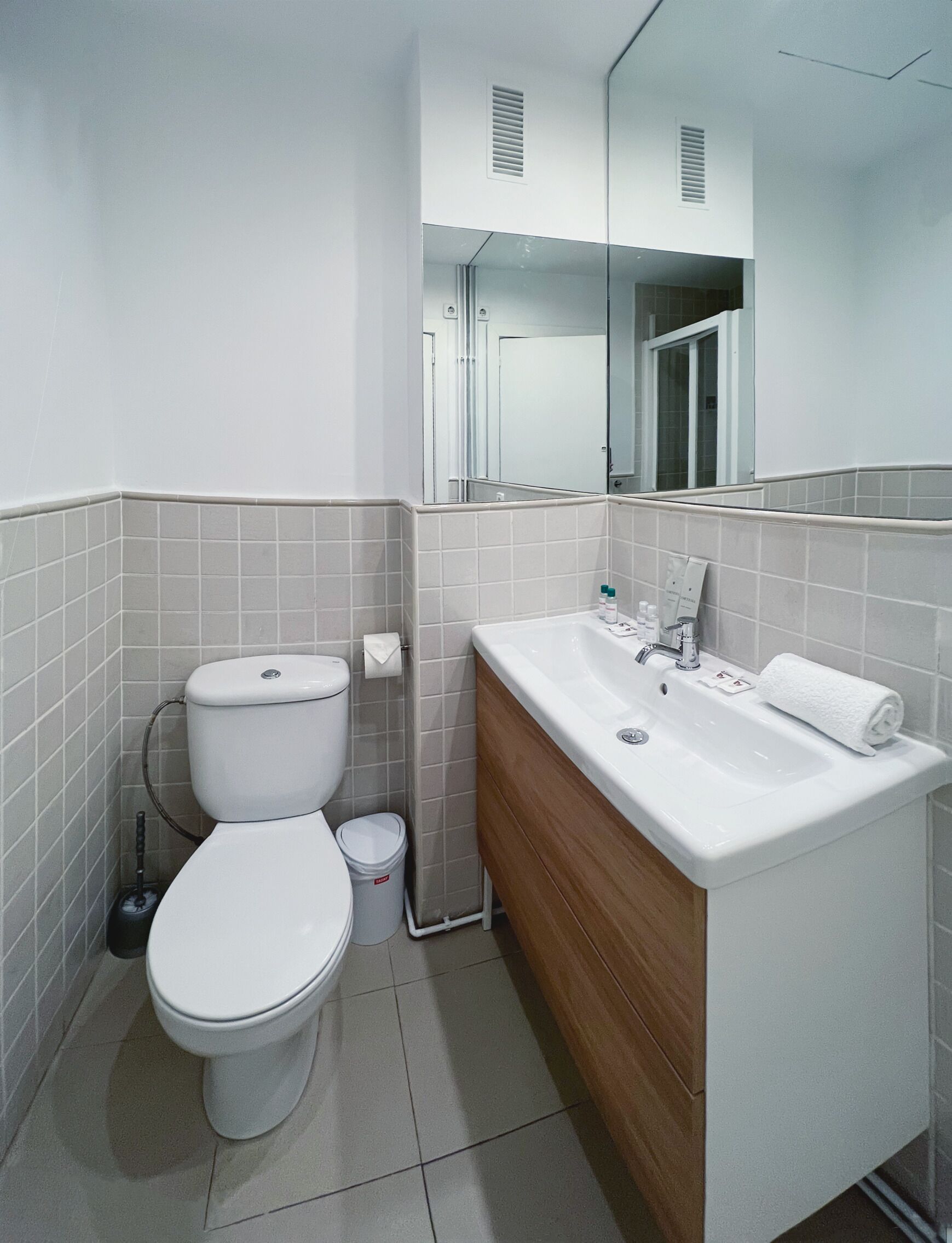 Un baño moderno con inodoro, lavabo y espejo.