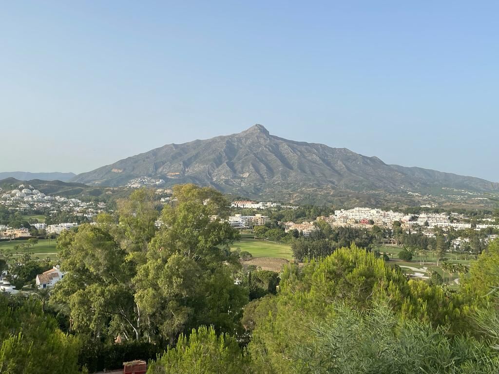 A mountain with a town in the valley below.