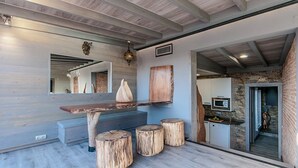 Eine moderne Küche mit einem Holztisch, Hocker und einem großen Spiegel.