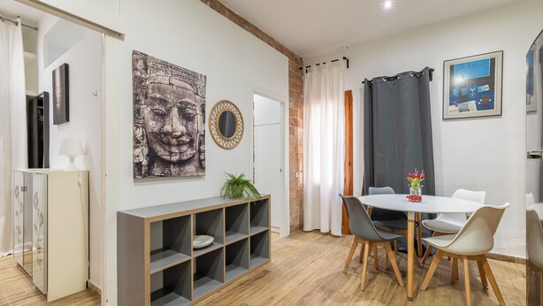 A modern dining area with a white table, grey chairs, and a wooden floor. - Stay U-nique Apartments Caminal (Barcelona)