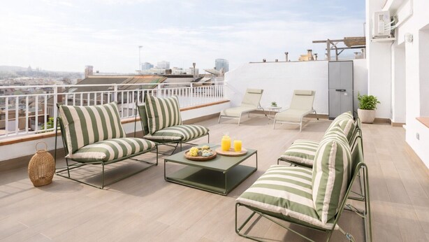 A rooftop terrace with outdoor seating, a small table with drinks, and a city view. - Stay U-nique Apartment Corsega II (Barcelona)