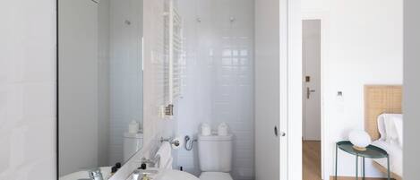 Un baño moderno con inodoro, lavabo y espejo.