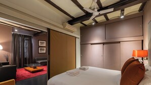 Una camera d'albergo con un letto, una scrivania, una sedia, un divano e un tappeto rosso.