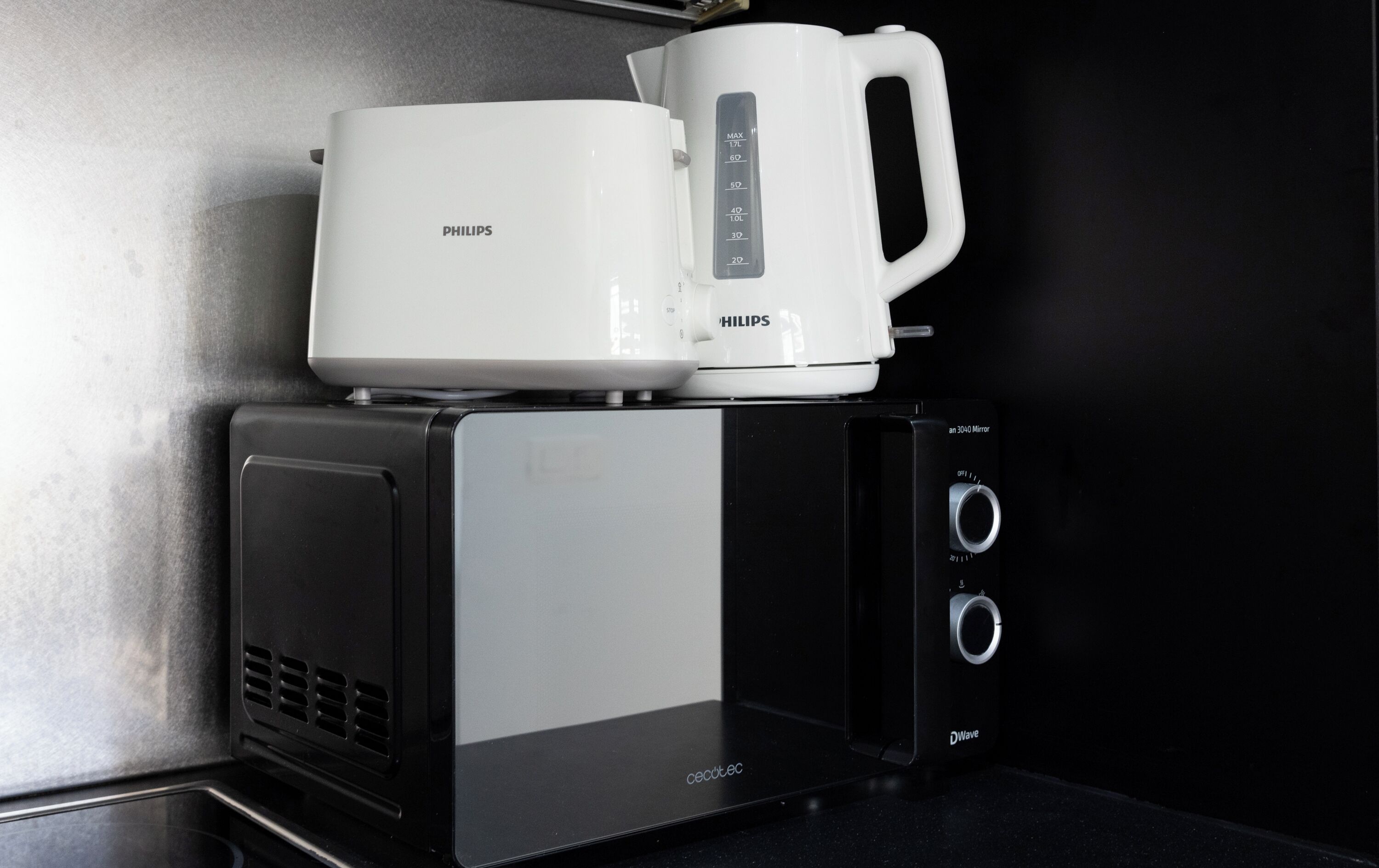 Un microondas pequeño con una cafetera encima.