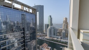 A high-rise building with a glass facade reflecting the cityscape. - Dubai Marina Studio for 2 With Sea Views (Dubai)