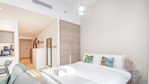 A modern hotel room with a large bed, a desk with a computer, and a wardrobe. - Dubai Marina Studio for 2 With Sea Views (Dubai)