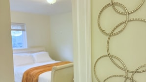 A bedroom with a bed, a window, and a wall-mounted decorative item.