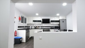 A modern kitchen with white cabinets, a black countertop, and stainless steel appliances.