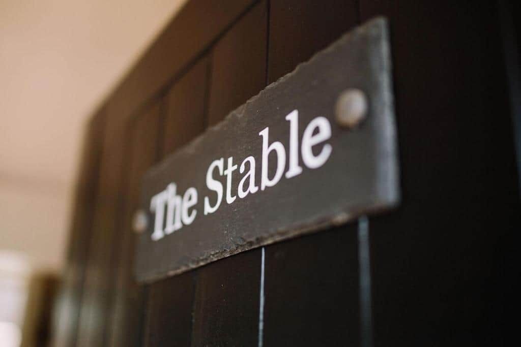 A sign with the text "The Stable" on a dark background.
