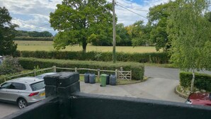 A rural driveway leading to a white house with a fenced yard and parked cars. - The George & Dragon Pub - The Hayloft (Horsham)