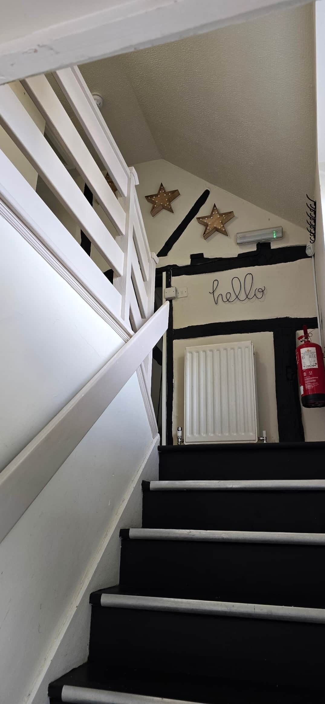 A staircase with white railings, a white radiator, and decorative stars on the wall.