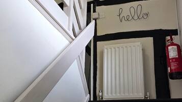 A staircase with white railings, a white radiator, and decorative stars on the wall.