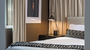 A hotel room with a bed, a nightstand, a lamp, and a framed picture on the wall. - Freshly remodeled home in Westminster. HotTub, Movie Theater, Pool Table, Arcade (Westminster)