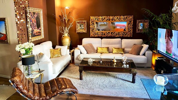 Un salon moderne avec un canapé blanc, un fauteuil en cuir marron et une table basse.