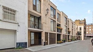 A row of modern buildings with balconies, large windows, and a clean, urban street. - Luxe 3BR/4BA Home w/ Air Con Games 5min Selfridges (Greater London)