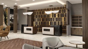 A modern lobby with a reception desk, seating area, and a decorative wall. - La Quinta Inn & Suites By Wyndham Jackson (Jackson)