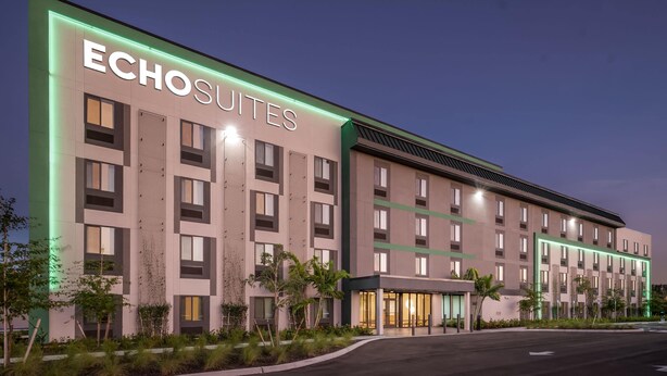 A modern hotel building with the name 'Echosuites' prominently displayed. It features a symmetrical facade with evenly spaced windows and a central entrance. - Echo Suites Extended Stay By Wyndham Naples (Naples)