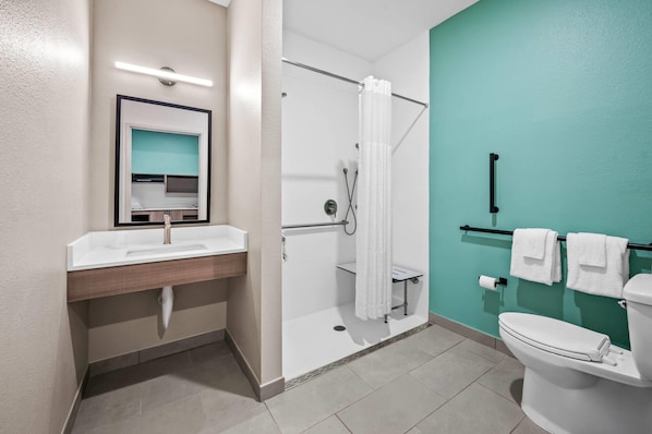 A modern bathroom with a sink, mirror, shower, and toilet. - Echo Suites Extended Stay By Wyndham Naples (Naples)