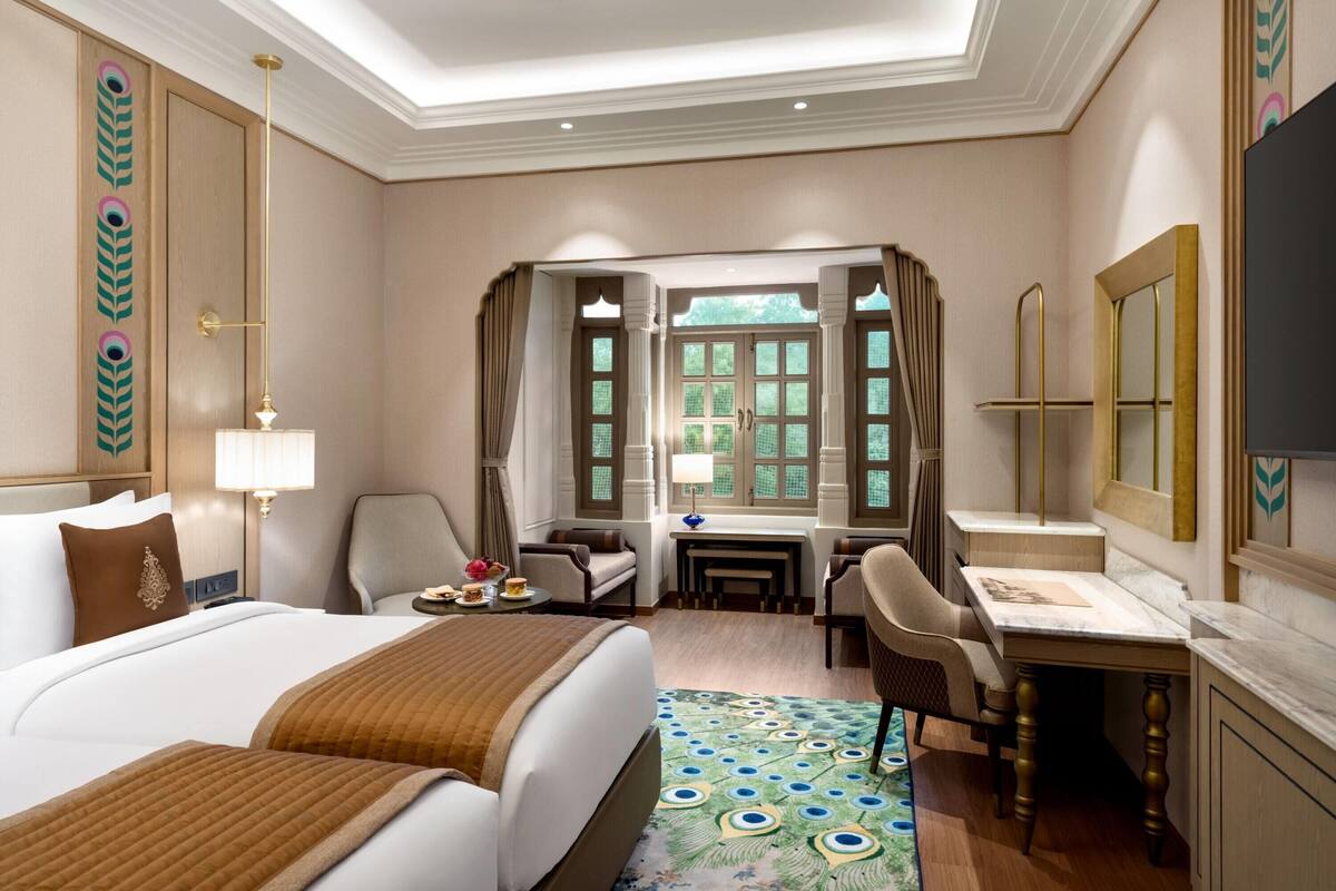 Ein Hotelzimmer mit einem großen Bett, einem Schreibtisch, einem Sessel und einem Fernseher.