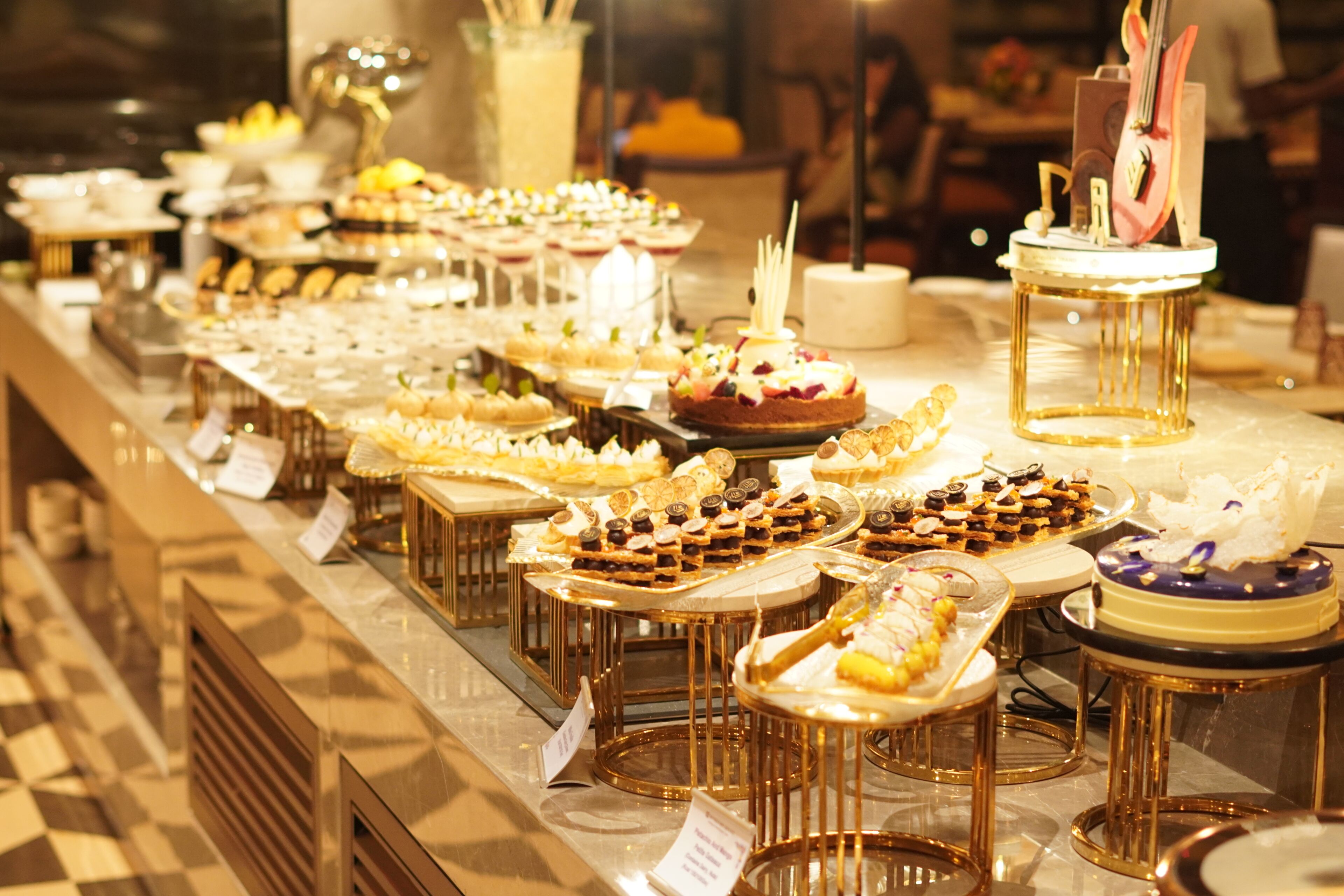 Un bufé con diversos postres y pasteles expuestos en bandejas.