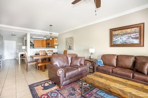 A living room with a brown leather sofa, a wooden coffee table, and a rug. - Mountain View Condo 1306 (Pigeon Forge)