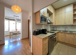 Une cuisine moderne avec des meubles en bois, un four à micro-ondes, un grille-pain et un évier.