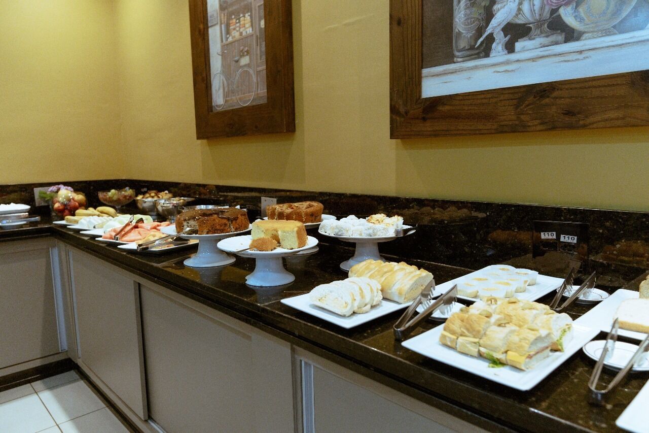 A buffet with various food items including cakes, pastries, and sandwiches.