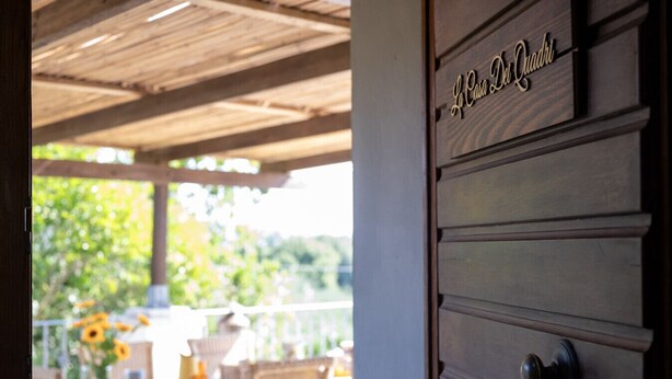 A wooden door with a sign that reads "La Casa De Quadro". - La Casa dei Quadri - Gavorrano (Bivio di Ravi Gavorrano)