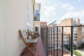 A balcony with a table and chairs, a view of neighboring buildings, and a clear sky. - Stay U-nique Apartments Sagrada Familia (Barcelona)